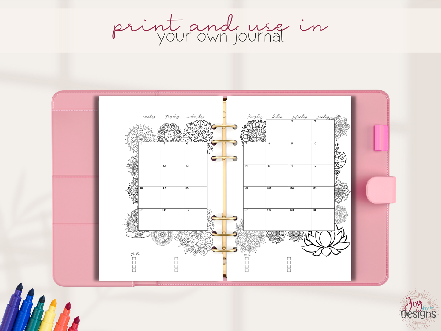 Pink notebook with mandala design pages and colorful markers on a white background