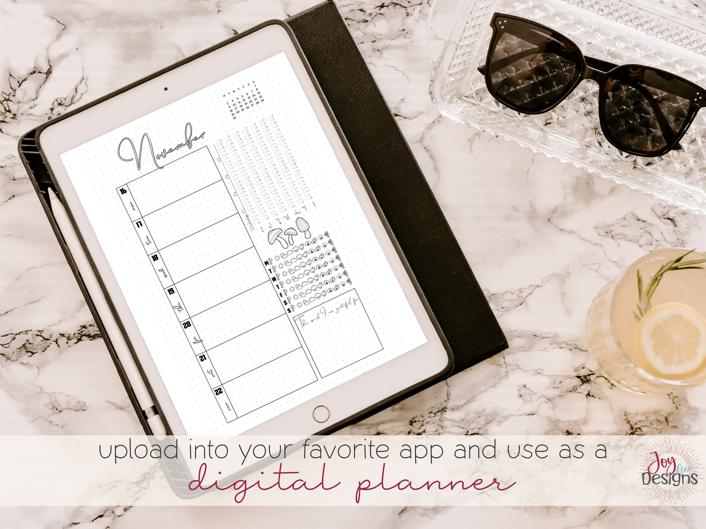 Digital planner on a tablet with sunglasses and a flower on a marble surface